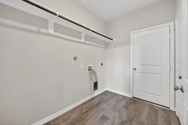 a view of a hallway with wooden floor and a window