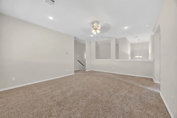 an empty room with windows and fan
