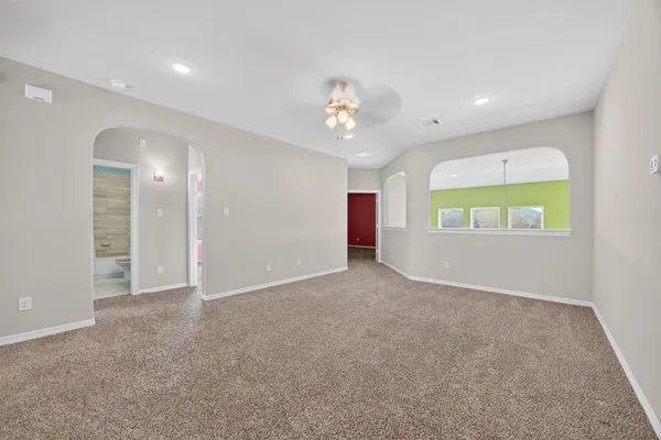 an empty room with windows and fan