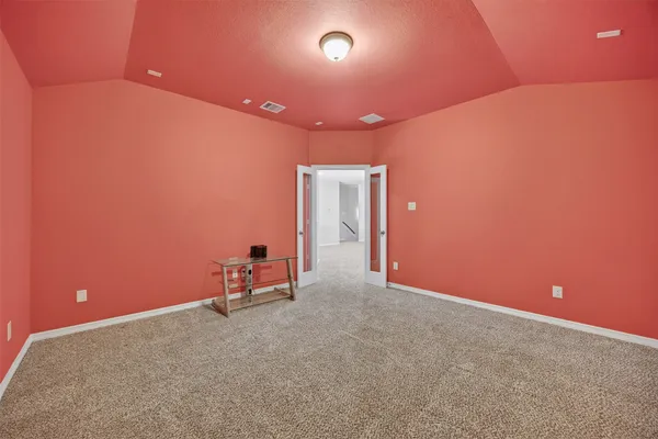 a view of an empty room and chandelier fan