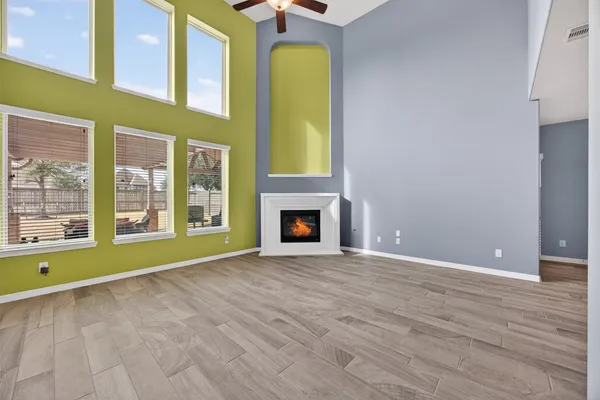 a view of an empty room with window and fire place