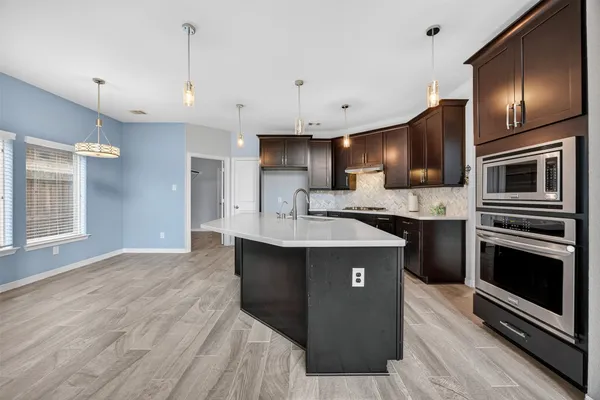 a kitchen with kitchen island granite countertop a sink stove and refrigerator