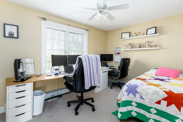 a view of a workspace with furniture and a window