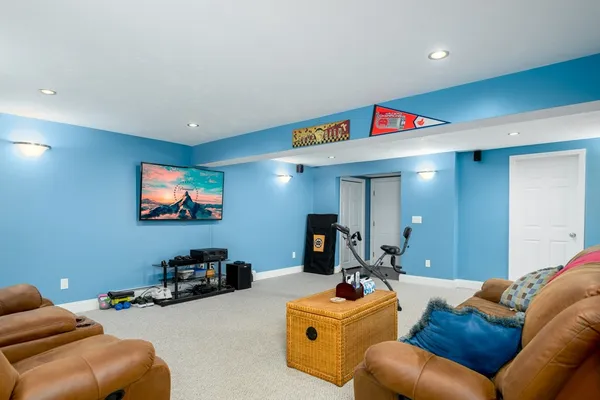 a living room with furniture kitchen view and a window