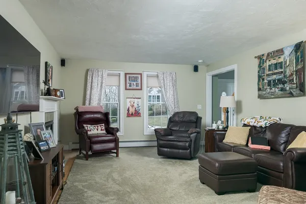 a living room with furniture a flat screen tv and a fireplace