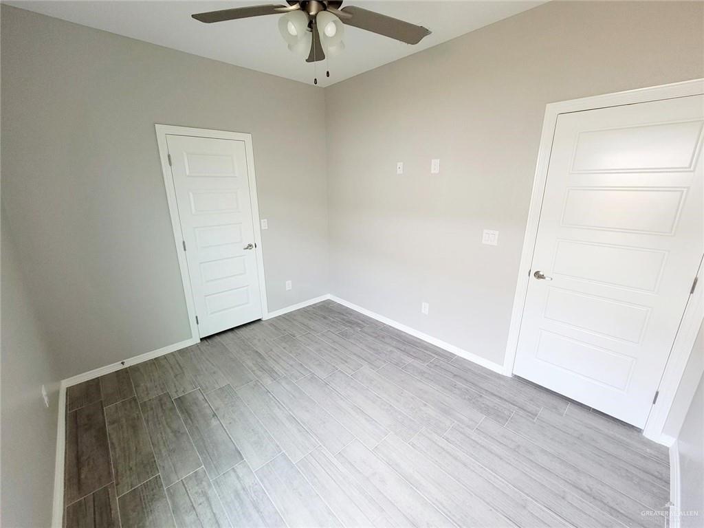 2109 Davenport Street, Unit 1 Weslaco, TX 78596 - Photo 3 of 13 an empty room with wooden floor and ceiling fan
