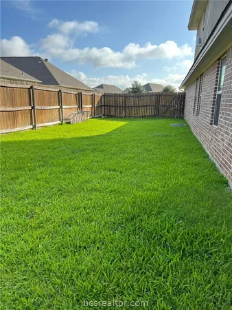 a view of a big room with a big yard and large trees
