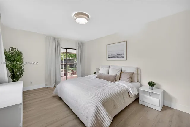 a large bed sitting in a bedroom next to a window and a potted plant