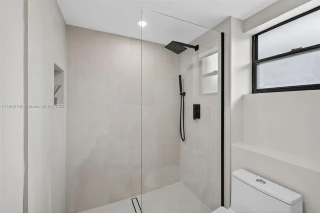 a bathroom with a shower and a glass door