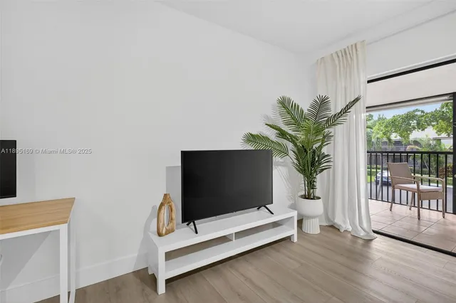 a living room with furniture bookshelf and a flat screen tv