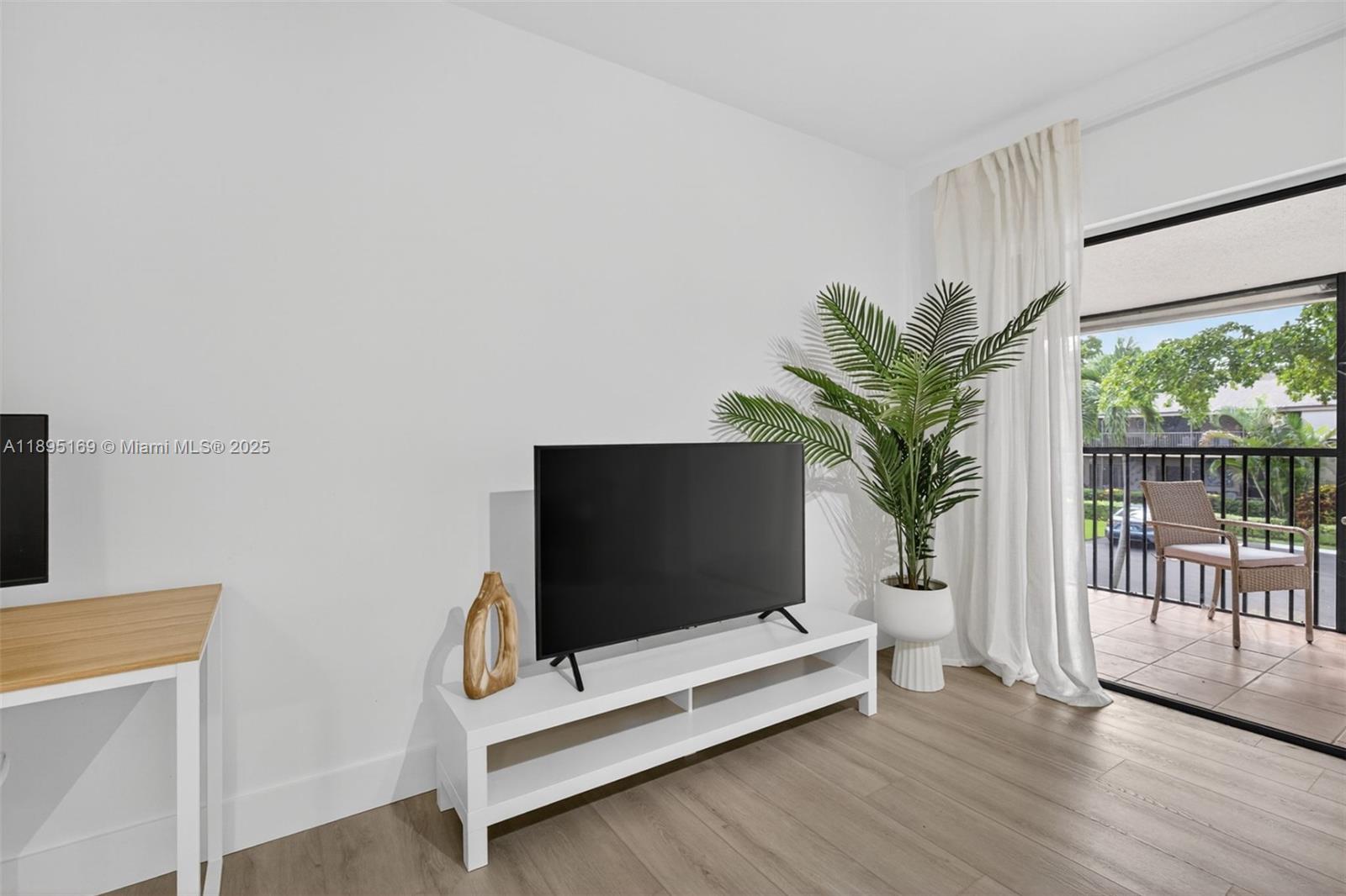 261 Deer Creek Boulevard, Unit 1205 Deerfield Beach, FL 33442 - Photo 21 of 38 a living room with furniture bookshelf and a flat screen tv