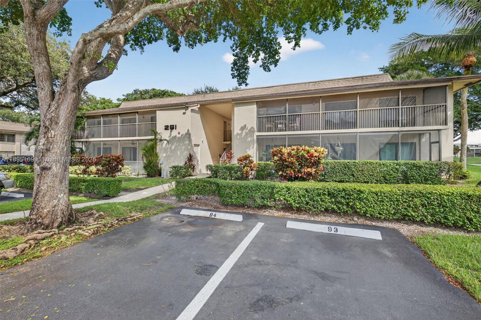 261 Deer Creek Boulevard, Unit 1205 Deerfield Beach, FL 33442 - Photo 23 of 38 a front view of a house with a yard and potted plants