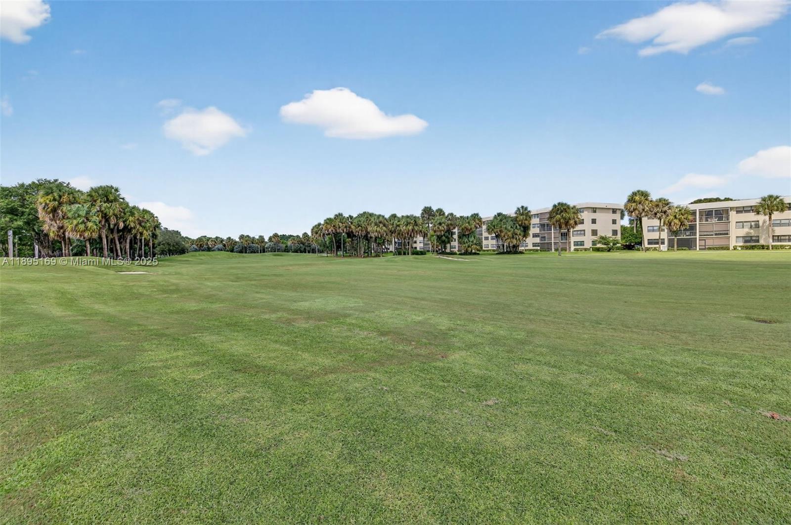 261 Deer Creek Boulevard, Unit 1205 Deerfield Beach, FL 33442 - Photo 27 of 38 a view of a golf course with a lake