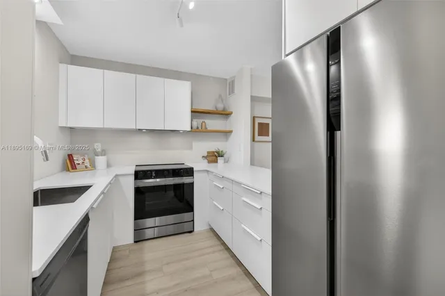 a kitchen with stainless steel appliances granite countertop a refrigerator and a stove