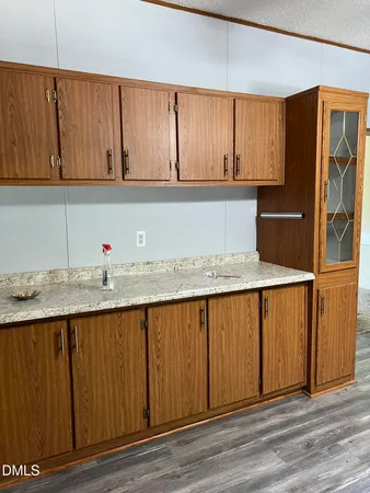a kitchen with granite countertop a sink cabinets and stainless steel appliances