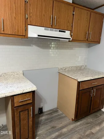 a kitchen with stainless steel appliances granite countertop wooden cabinets a sink and dishwasher