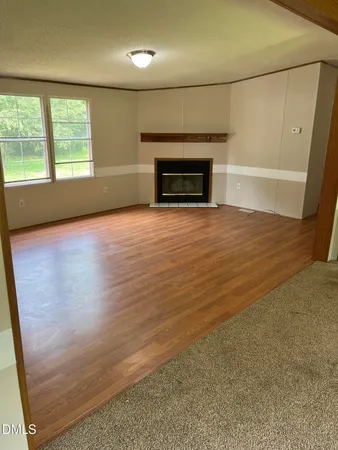 en empty room with window and fireplace