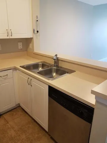 a metallic refrigerator freezer sitting in a kitchen