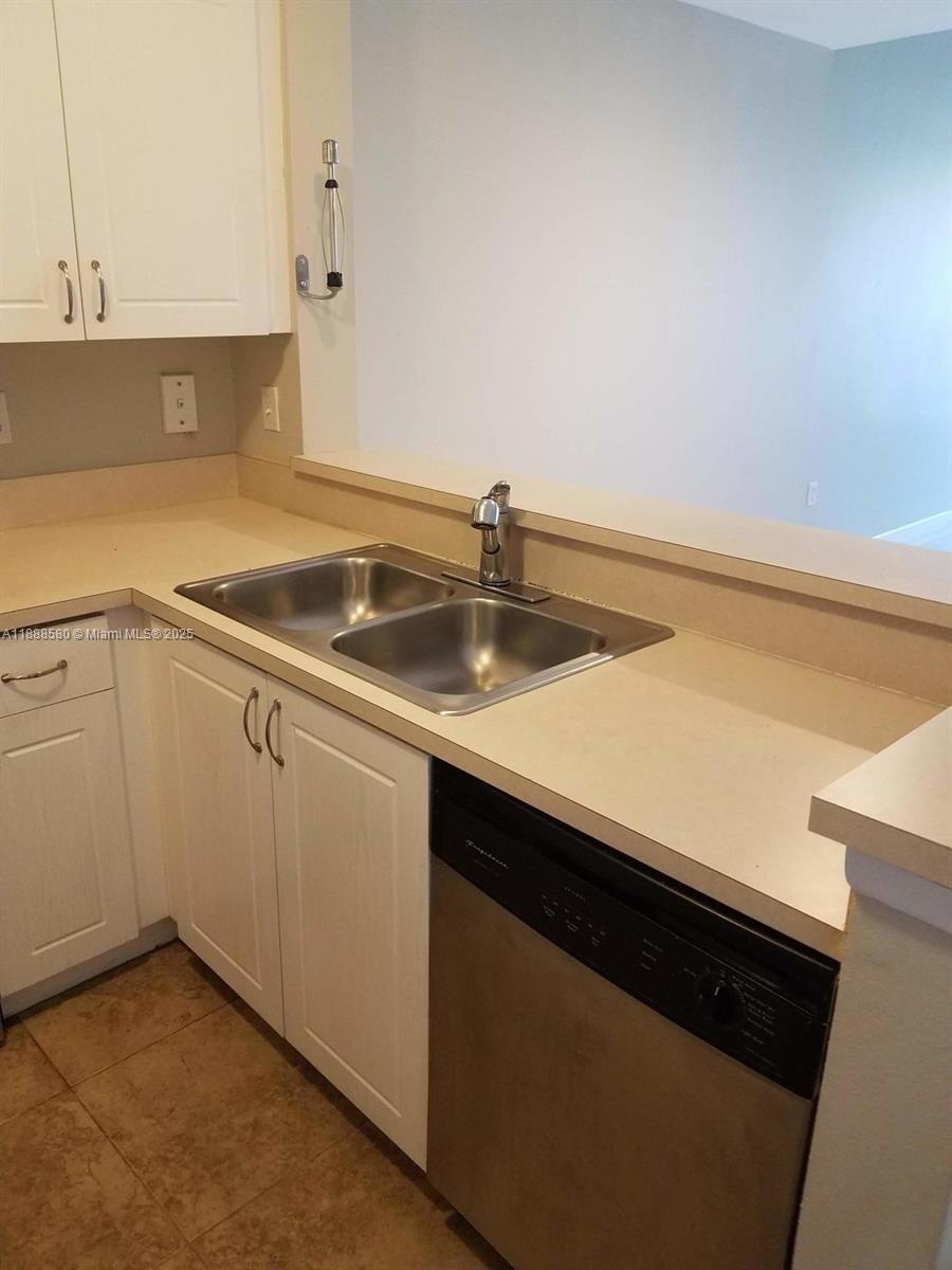 4863 Via Palm Lakes, Unit 806 West Palm Beach, FL 33417 - Photo 21 of 23 a kitchen with a sink and cabinets