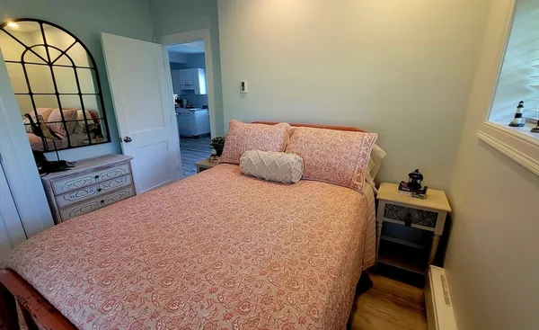 a bedroom with a bed and a flat tv screen on dresser