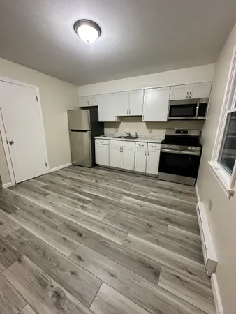 a kitchen with granite countertop white cabinets and appliances