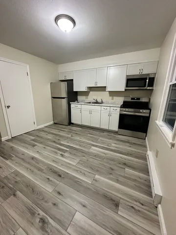 a kitchen with granite countertop white cabinets and appliances