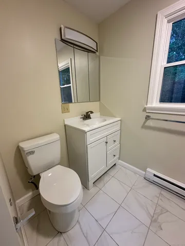 a bathroom with a toilet sink and mirror