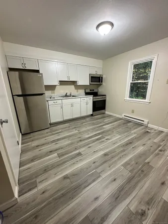 a view of kitchen with cabinets and refrigerator