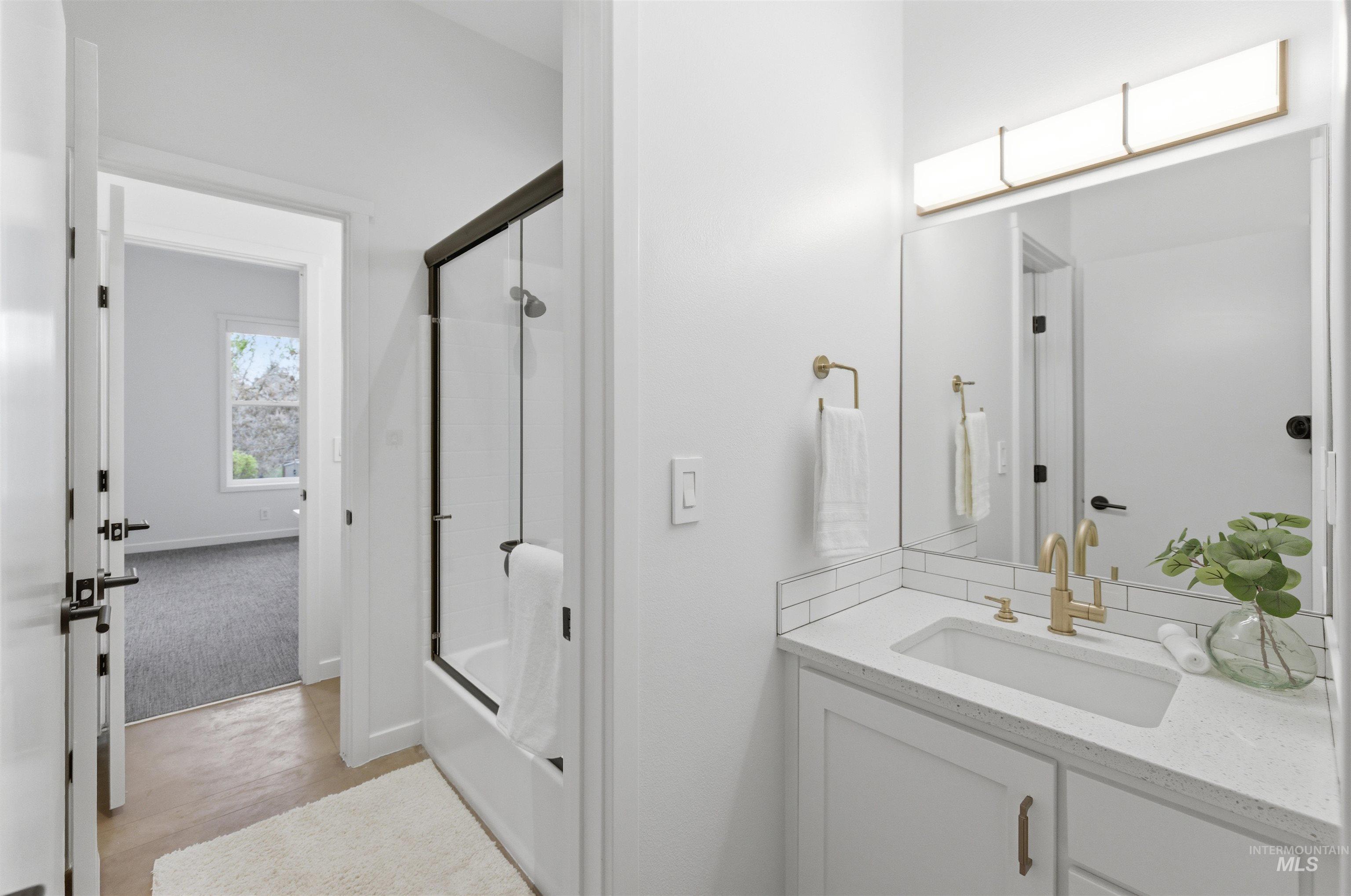 4275 36th Street Boise, ID 83703 - Photo 14 of 50 Bathroom featuring vanity, bath / shower combo with glass door, and light colored carpet