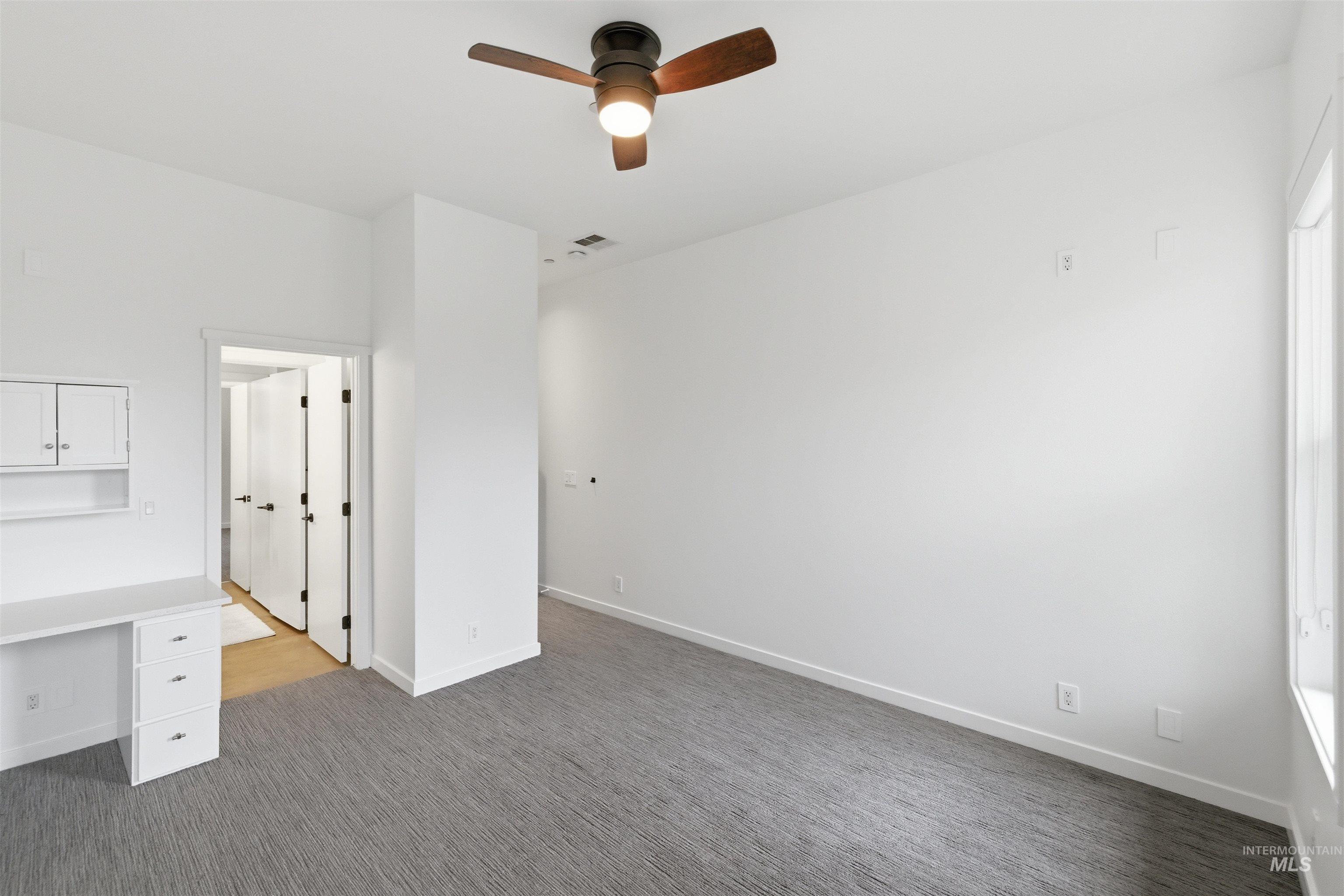 4275 36th Street Boise, ID 83703 - Photo 16 of 50 Unfurnished bedroom featuring dark carpet, a ceiling fan, and built in desk