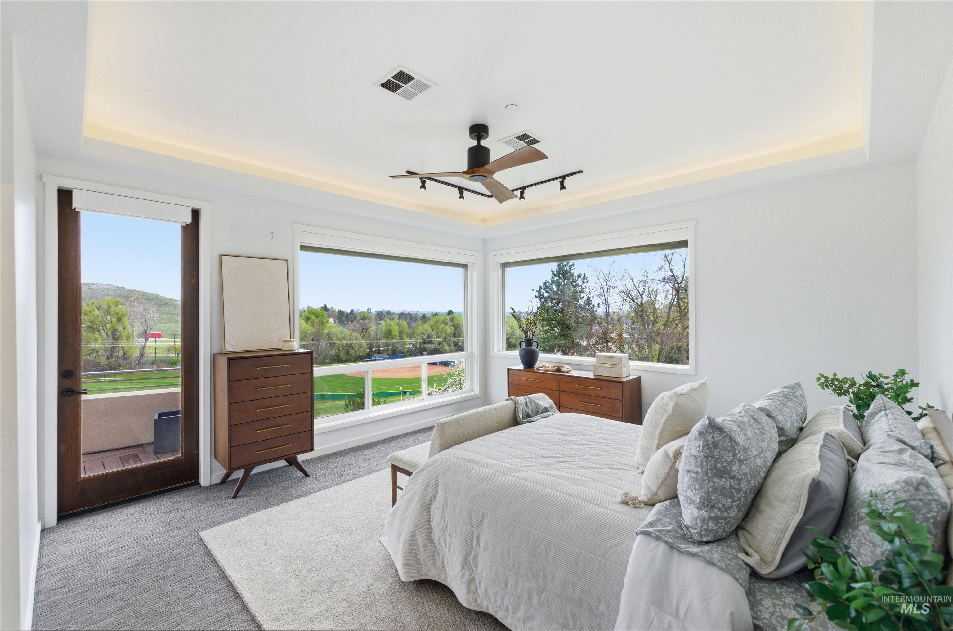 4275 36th Street Boise, ID 83703 - Photo 17 of 50 Bedroom with a raised ceiling, light carpet, access to outside, a ceiling fan, and multiple windows