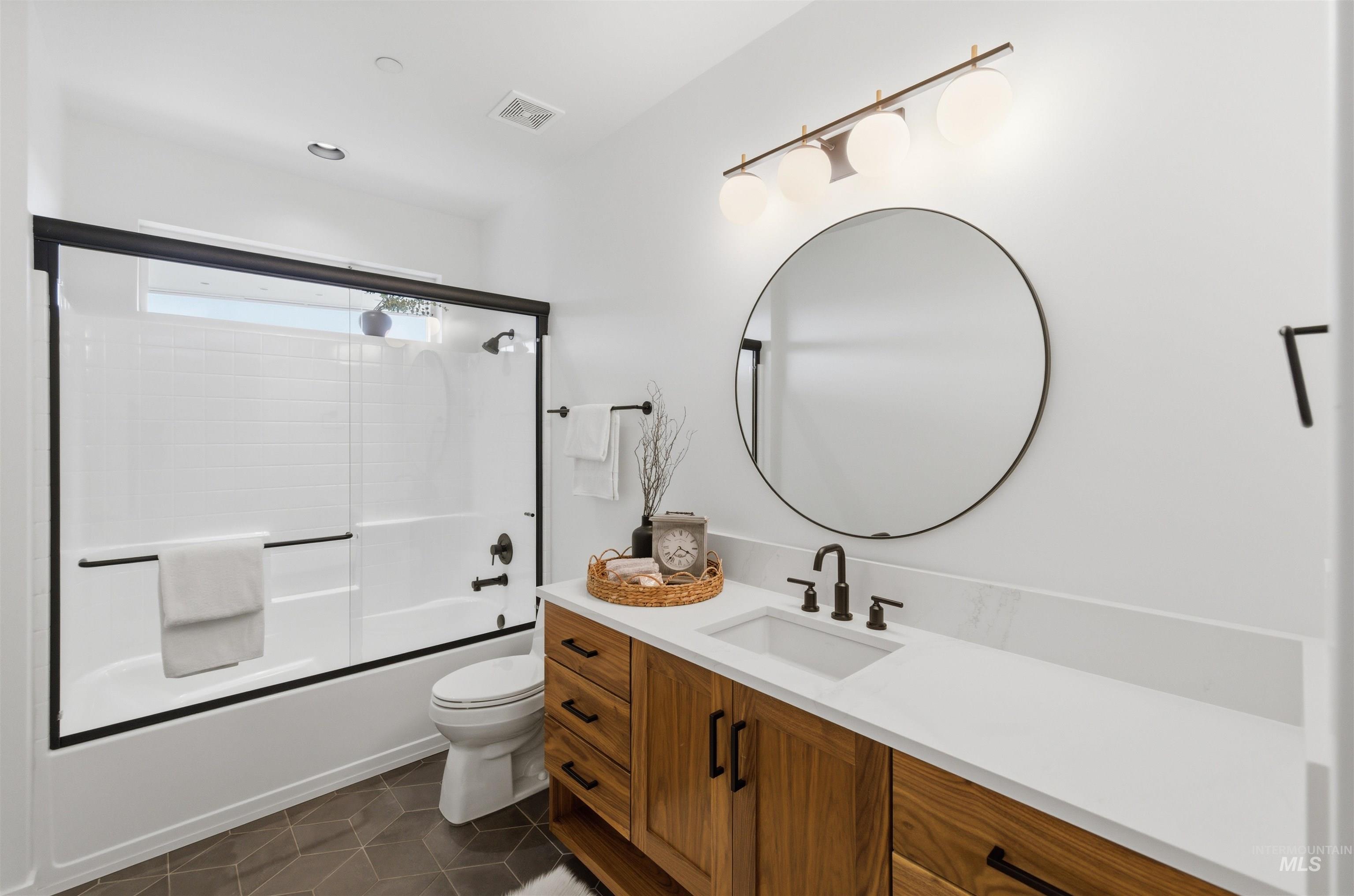 4275 36th Street Boise, ID 83703 - Photo 32 of 50 Full bathroom featuring vanity, dark tile patterned flooring, and combined bath / shower with glass door