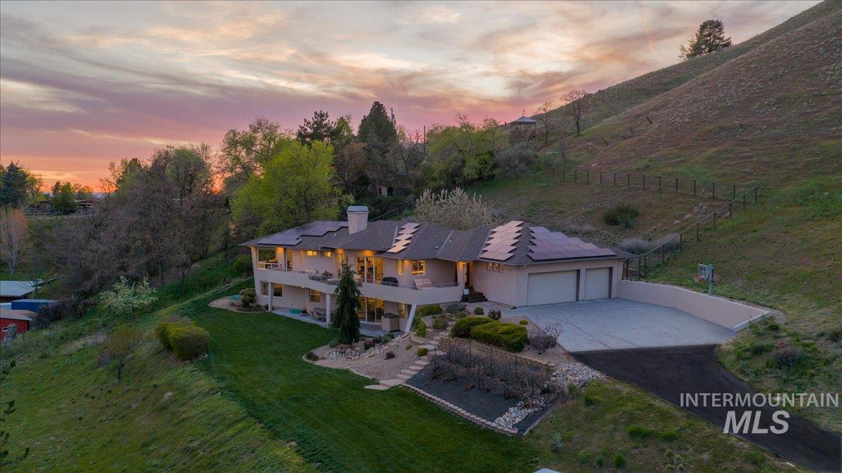 4275 36th Street Boise, ID 83703 - Photo 44 of 50 View of front facade featuring solar panels, a patio area, driveway, a chimney, and a garage