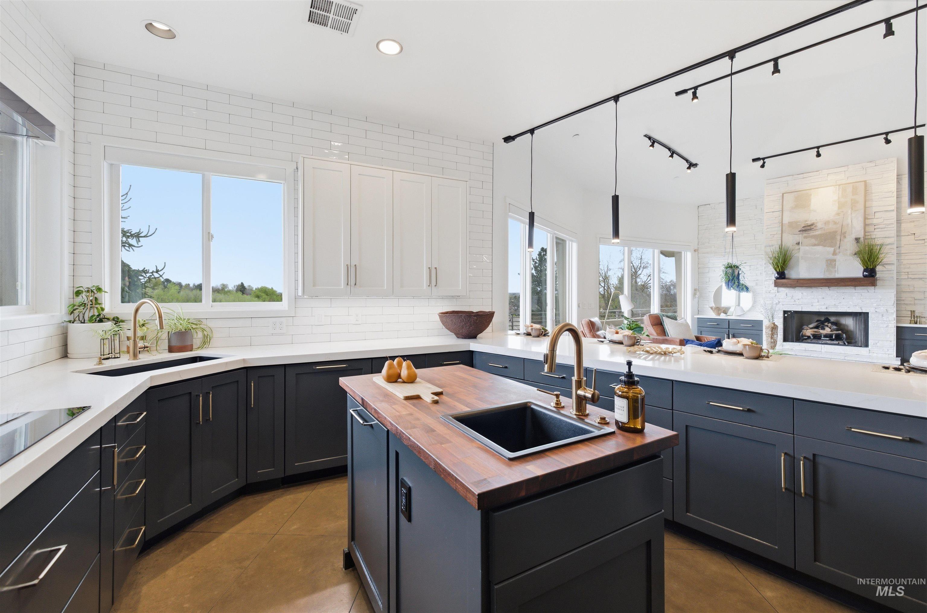 4275 36th Street Boise, ID 83703 - Photo 50 of 50 Dual tone kitchen with open floor plan, butcher block countertops, a fireplace, decorative backsplash, and plenty of natural light
