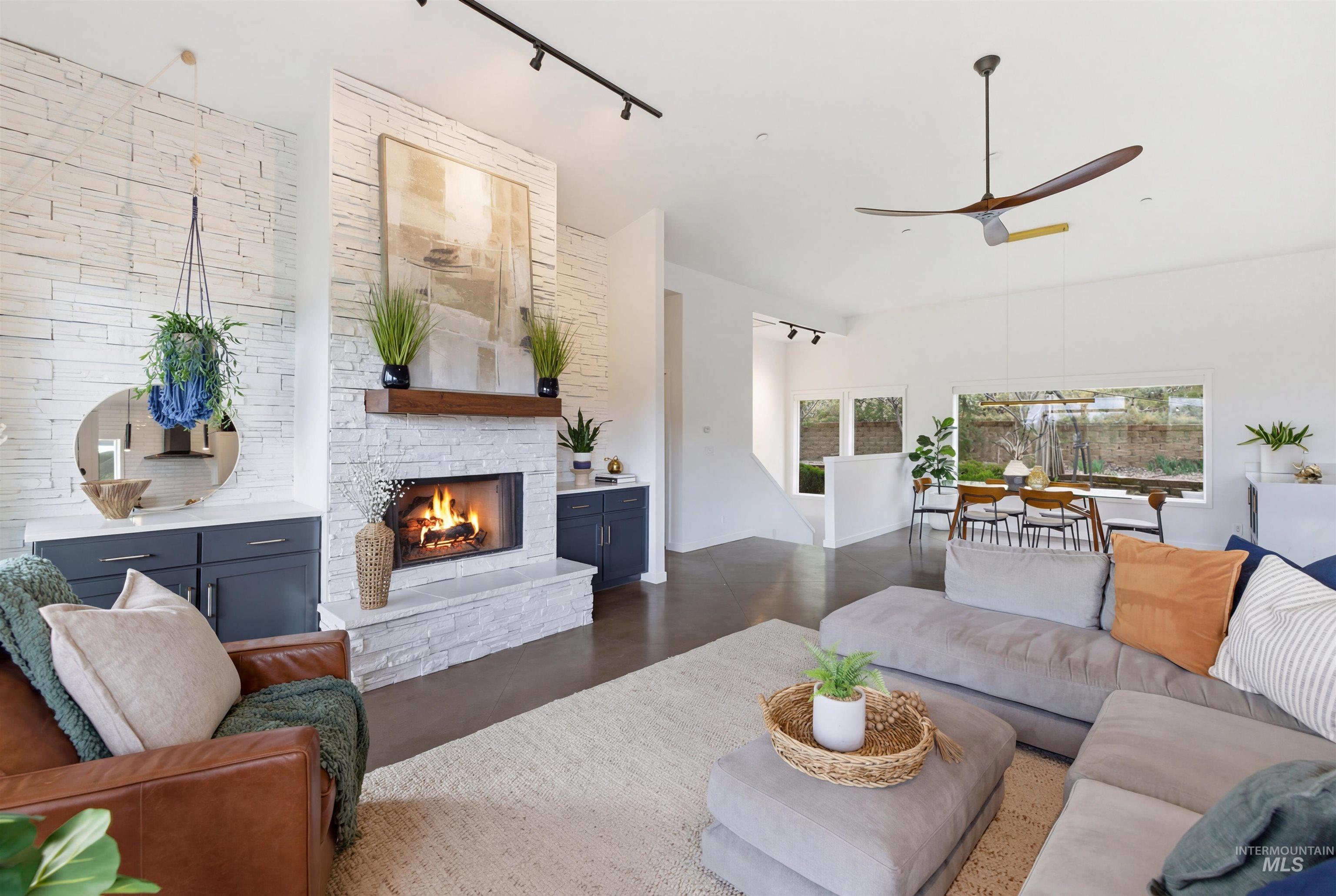 4275 36th Street Boise, ID 83703 - Photo 9 of 50 Living area featuring rail lighting, a stone fireplace, concrete floors, and ceiling fan