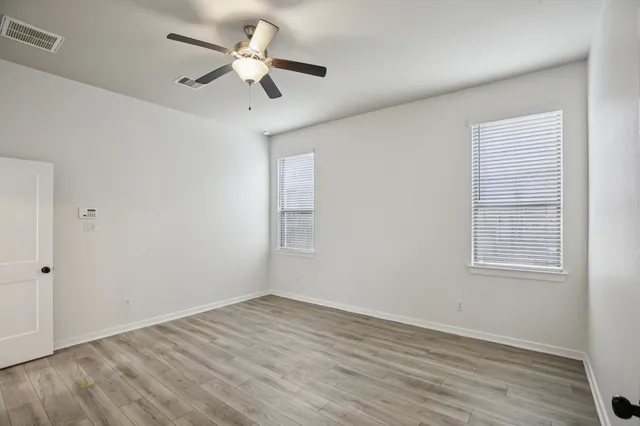 a view of empty room with wooden floor