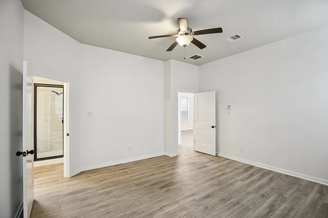a view of a hallway with wooden floor and closet area