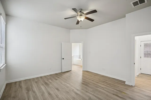 a view of an empty room with wooden floor