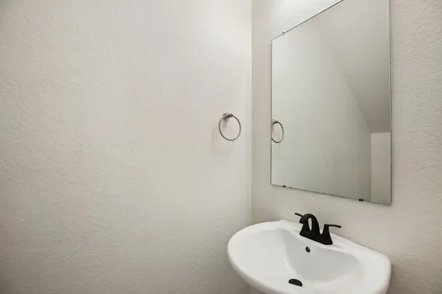a bathroom with a sink a toilet and a mirror