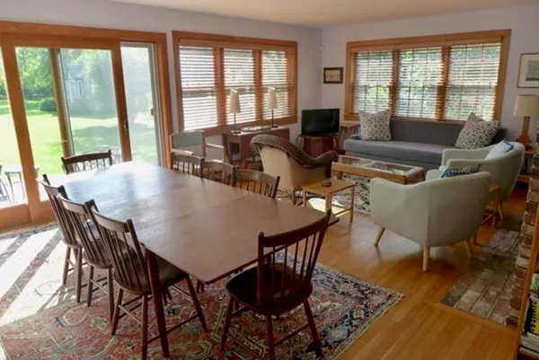 a view of a dining room with furniture wooden floor and a potted plant