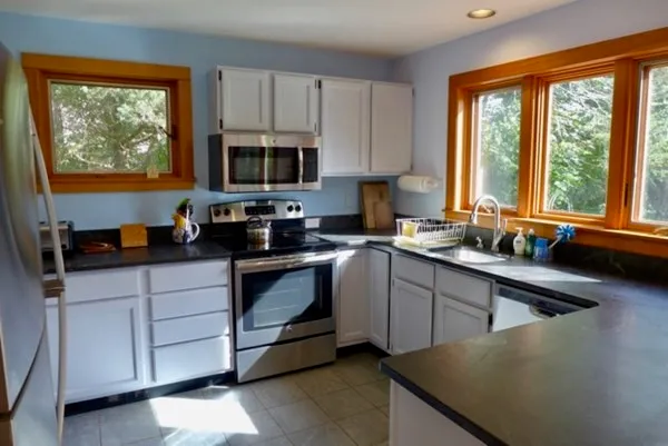 a kitchen with stainless steel appliances granite countertop a stove a sink and a microwave
