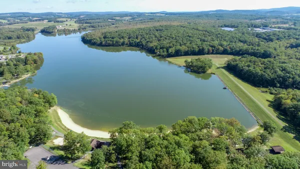 an aerial view of lake residential house with outdoor space and trees around