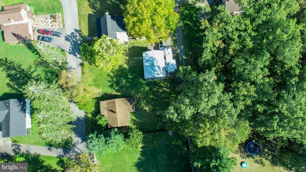 an aerial view of a house with a yard and trees all around