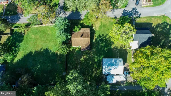 an aerial view of residential house with outdoor space and trees all around
