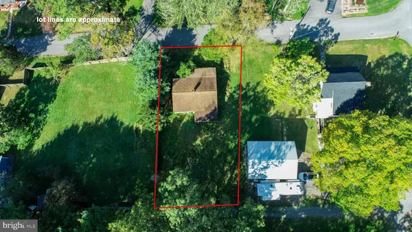 an aerial view of residential house with outdoor space and trees all around