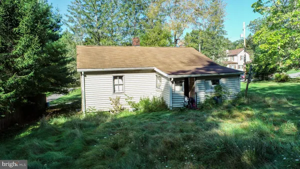 a view of a house with a small yard plants and large tree