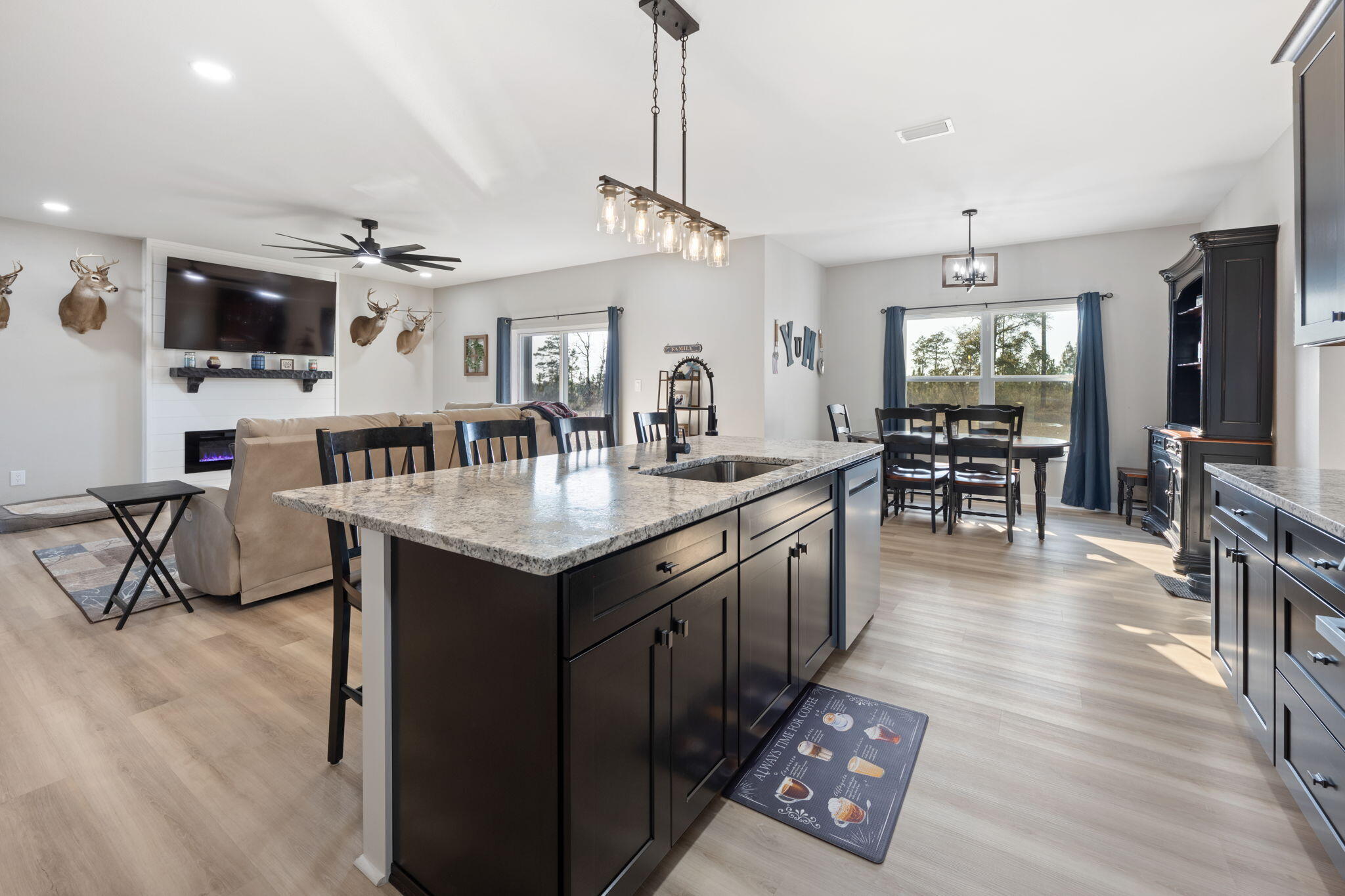 6150 Sherman Kennedy Road Baker, FL 32531 - Photo 10 of 43 a open kitchen with stainless steel appliances granite countertop a sink dishwasher a dining table and chairs with wooden floor
