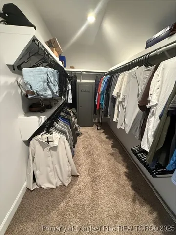 a view of walk in closet with clothes and shoes