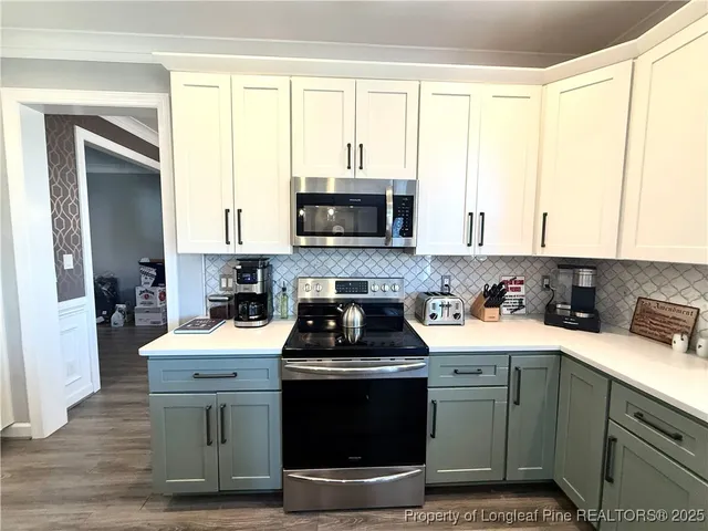 a kitchen with stainless steel appliances a stove a sink and a microwave