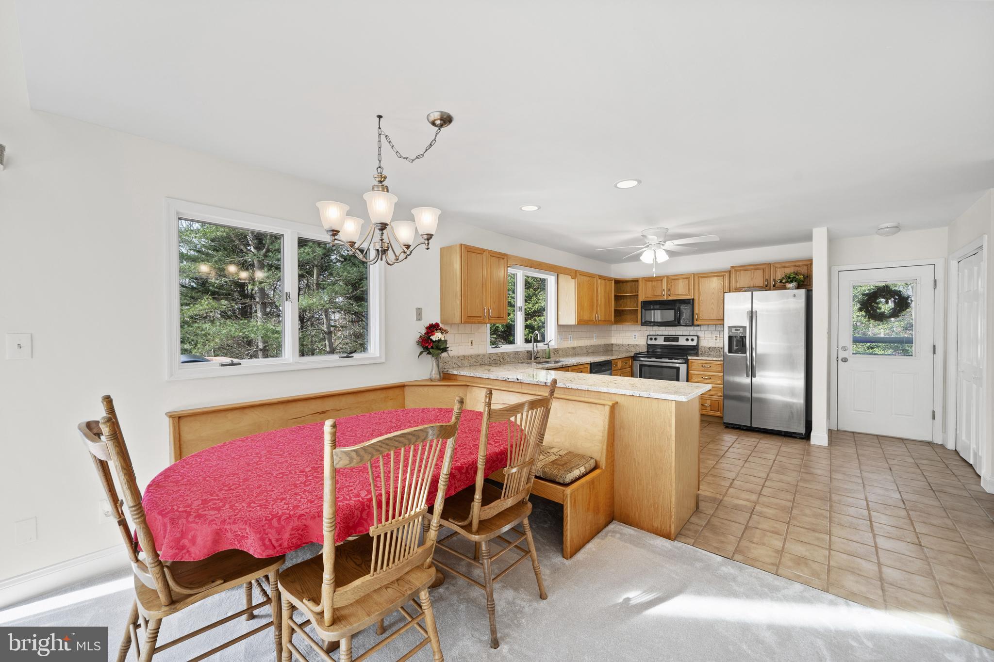 6251 Stephen Reid Road Huntingtown, MD 20639 - Photo 18 of 46 a kitchen with a dining table chairs sink and granite counter tops
